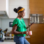 Mature woman using smartphone in the kitchen at home